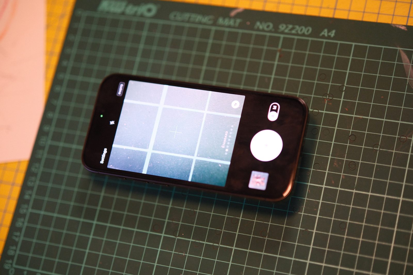 The same iPhone on the cutting mat, from another angle